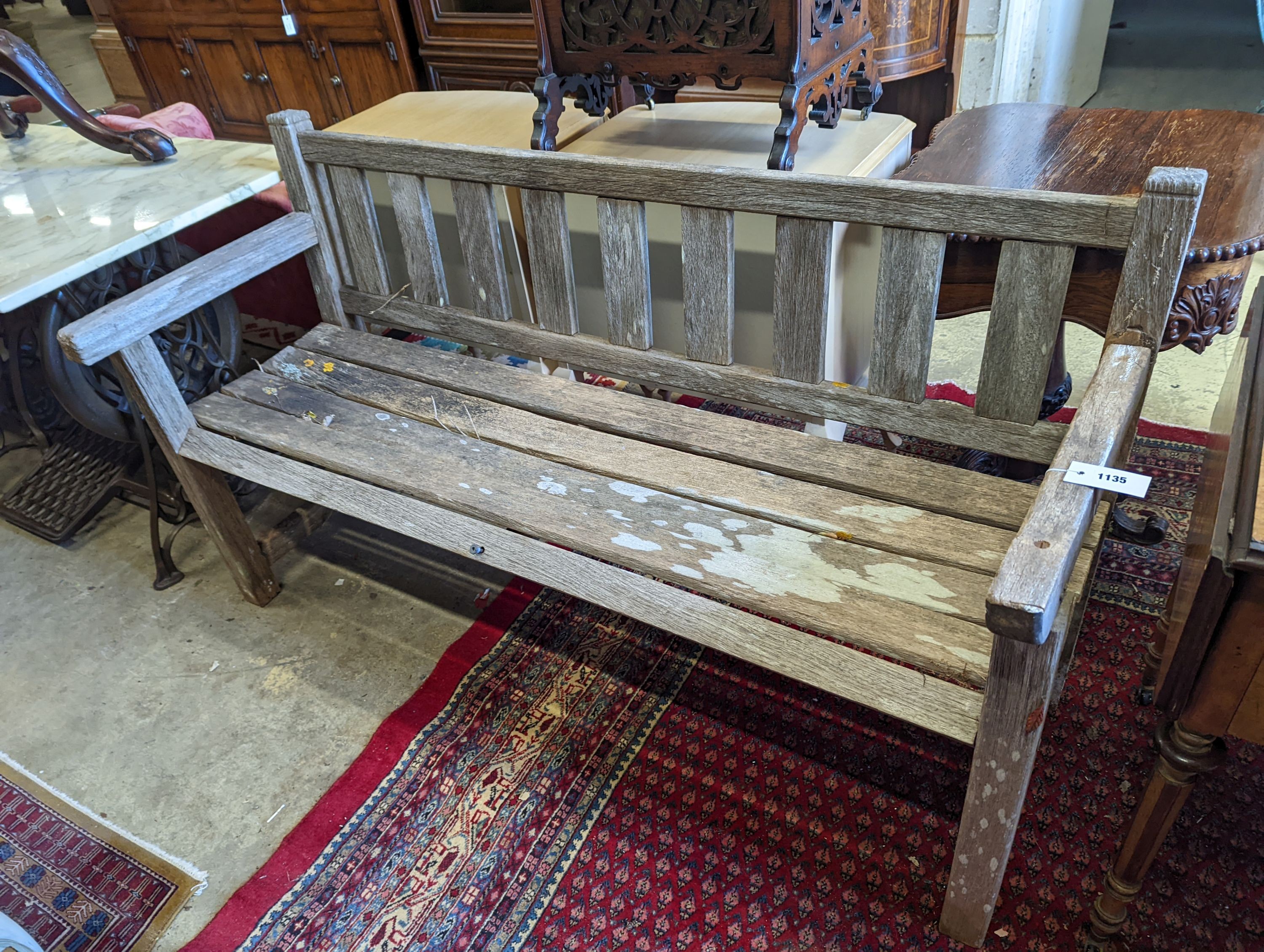 A weathered teak slatted garden bench, length 151cm, depth 56cm, height 86cm